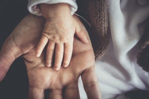 Toddler's hand on top of adults hands