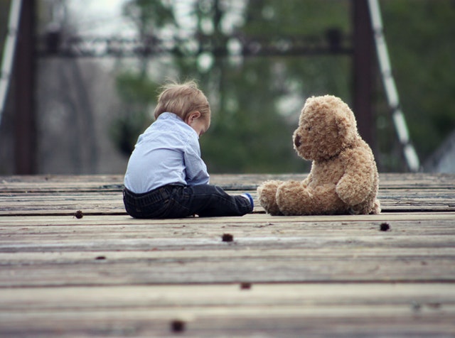 child and teddy bear on bridge, lonely